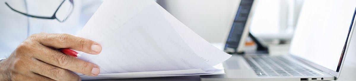 gros plan sur la main d’une personne qui tient une pile de papiers